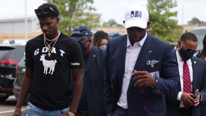 Deion Sanders walks with son Shedeur Sanders ahead of the Hall of Famer's introductory press conference at Jackson State football's head coach